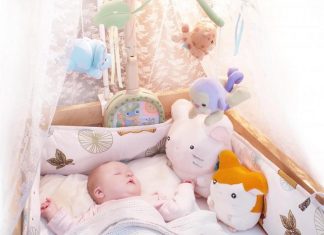 picture of baby sleeping in bed with stuffed animals