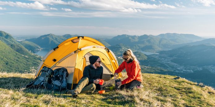 Couple sitting in 2 man tent on the top of mountain