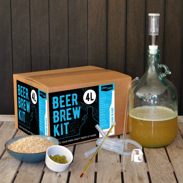 Box of beer brewing kit with beer making bottle, yeast and hops beside it